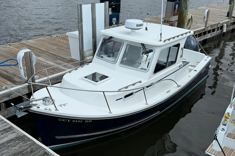 Slide: The Image of 2020 Eastern 248 Islander boat docked at a marina, featuring a sleek white cabin. - 9