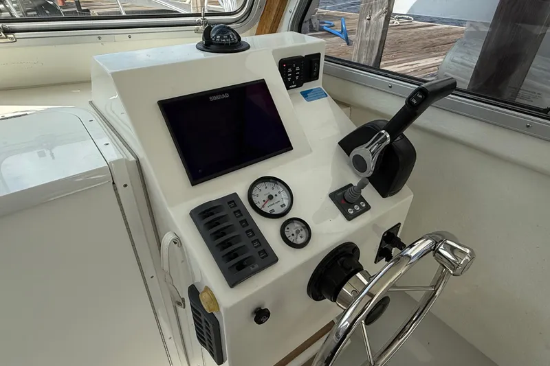 Slide: The Image of Control panel of 2020 Eastern 248 Islander boat with steering wheel and navigation instruments. - 3