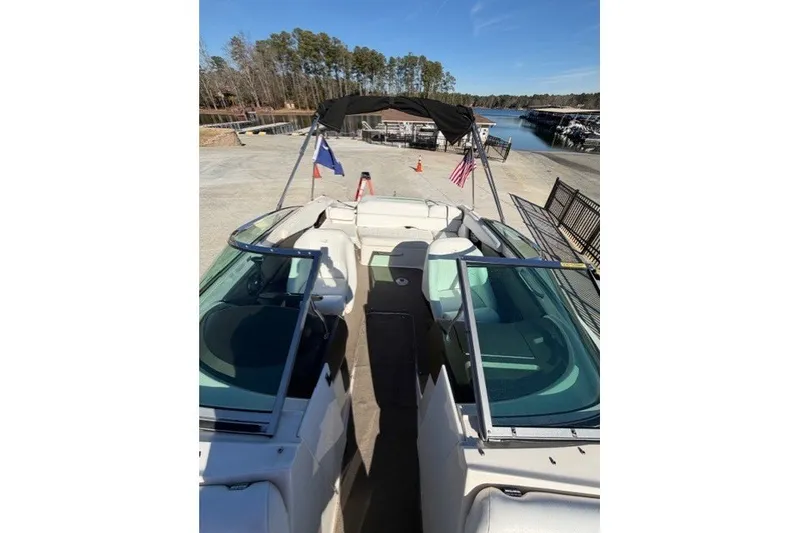 Slide: The Image of 2005 Regal 2200 Bowrider boat docked, featuring spacious seating and a canopy. - 8