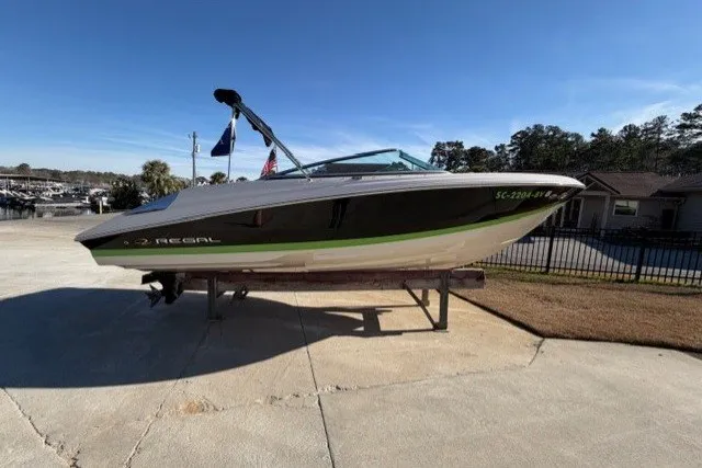 The Image of 2005 Regal 2200 Bowrider boat on trailer, parked outdoors under clear sky. - 1