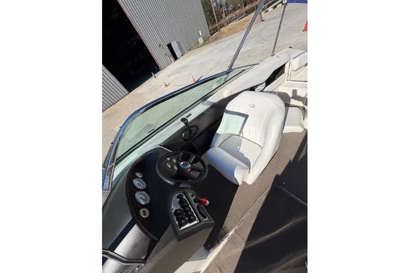 Slide: The Image of 2005 Regal 2200 Bowrider boat interior with steering wheel and white seating. - 6