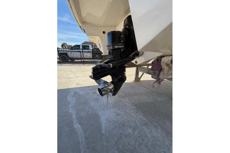 Slide: The Image of 2005 Regal 2200 Bowrider boat with MerCruiser outdrive, parked on concrete surface. - 11