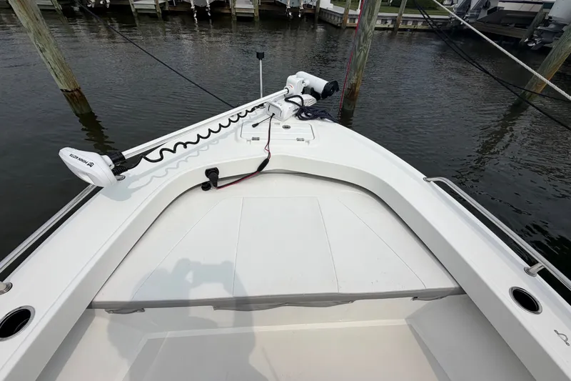 Slide: The Image of 2024 Parker 1801 Center Console boat docked, featuring a clean white deck and trolling motor. - 6