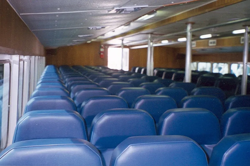 Slide: The Image of Interior of a 1994 Breaux's Bay Craft vessel, featuring rows of blue passenger seats. - 3