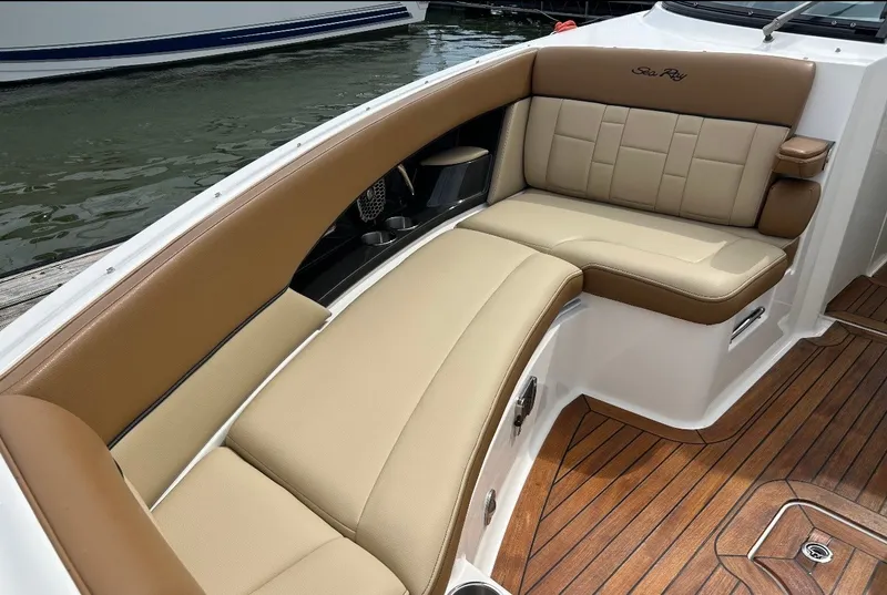 Slide: The Image of The 2015 Sea Ray SLX 350 features an elegant, cushioned seating area with brown and beige upholstery. - 7