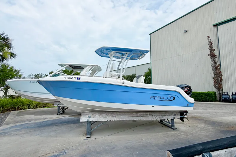 Slide: The Image of 2024 Robalo R222 Center Console boat in blue, displayed outdoors on a stand. - 1