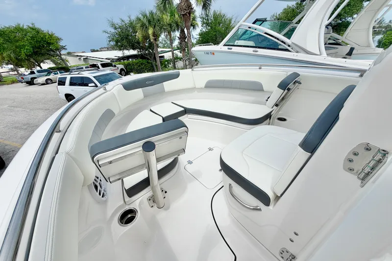 Slide: The Image of 2024 Robalo R222 Center Console boat interior with seating and console, parked outdoors. - 26