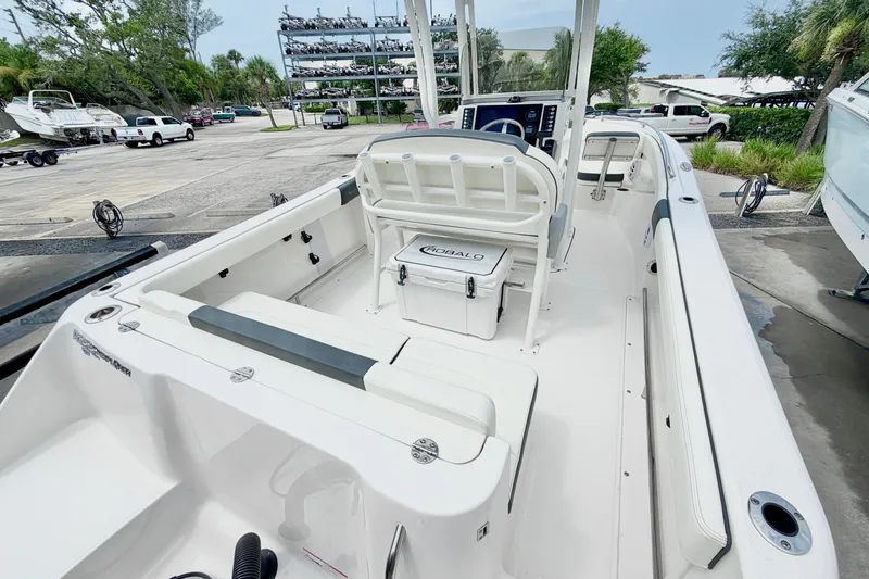 Slide: The Image of 2024 Robalo R222 Center Console boat interior with seating and storage, docked outdoors. - 8