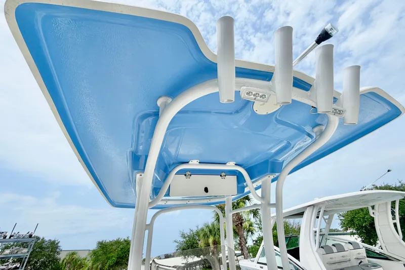 Slide: The Image of 2024 Robalo R222 Center Console boat with blue T-top and rod holders. - 14
