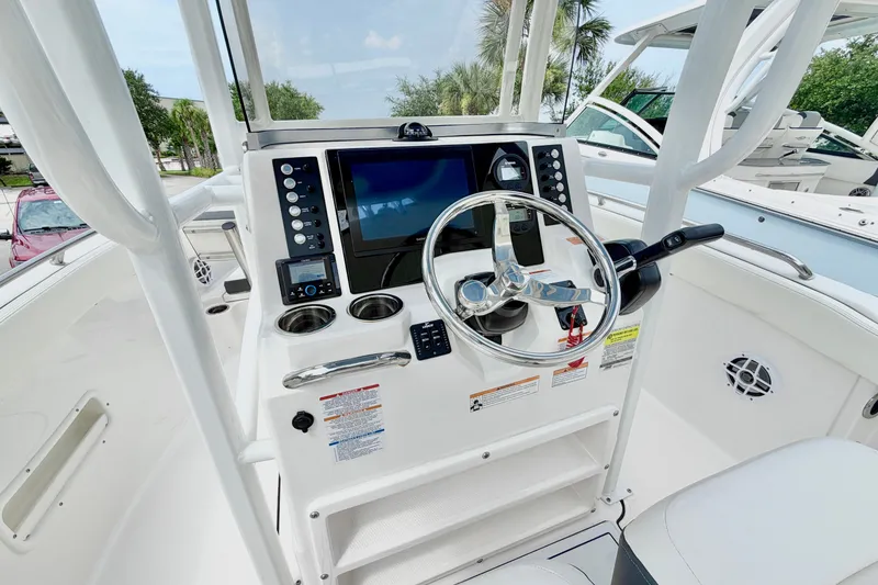 Slide: The Image of 2024 Robalo R222 Center Console boat dashboard with steering wheel and navigation controls. - 17
