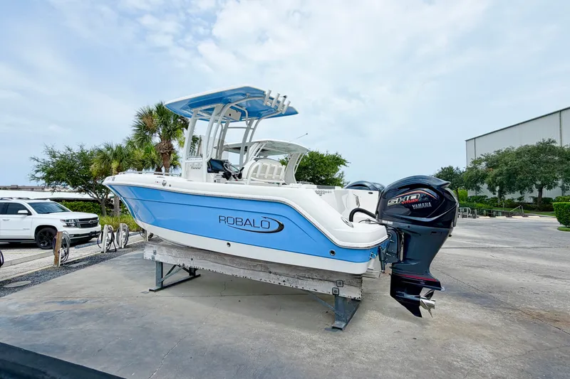 Slide: The Image of 2024 Robalo R222 Center Console boat with Yamaha engine on display outdoors. - 2