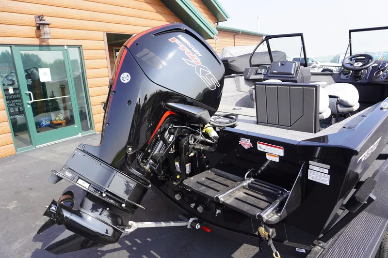 Slide: The Image of 2027 Tracker Pro Guide V-175 Combo boat with powerful outboard motor, parked outside a building. - 3
