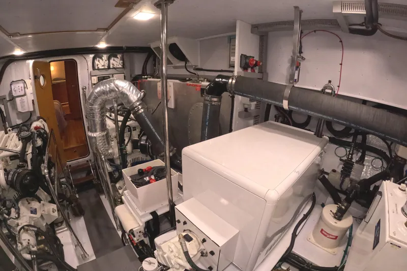 Slide: The Image of The engine room of a 2021 Krogen 50 Open features complex piping and machinery. - 51