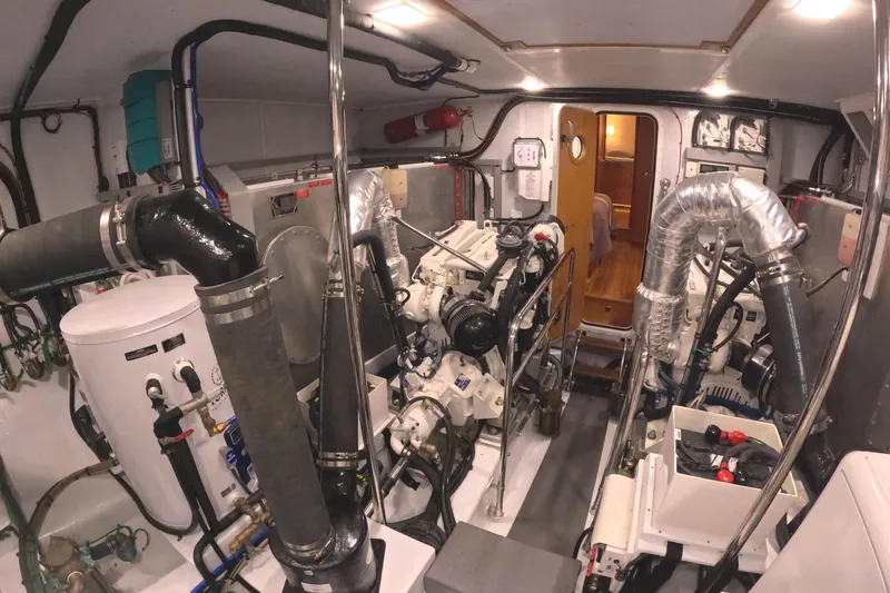 Slide: The Image of The engine room of a 2021 Krogen 50 Open features complex engines and piping. - 52