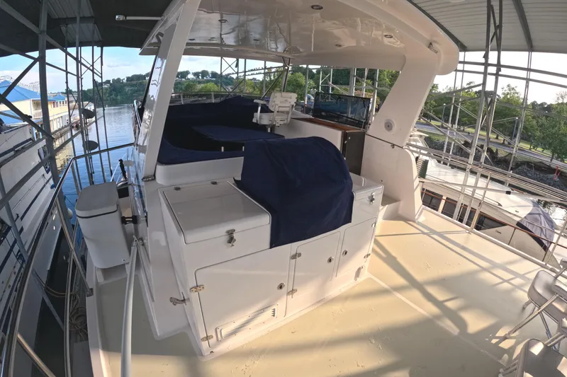 Slide: The Image of Kadey-Krogen 50 Open 2021 yacht deck with covered seating and storage, docked by the water. - 34