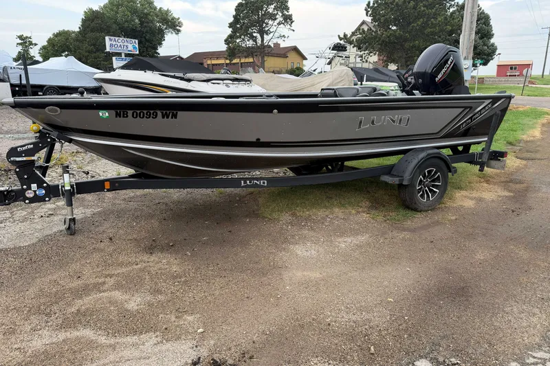 Slide: The Image of 2025 Lund 1875 Pro Guide fishing boat on trailer, parked outdoors. - 3