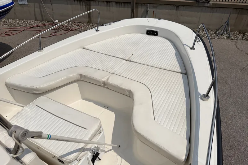 Slide: The Image of 2000 Boston Whaler 22 Dauntless boat with white cushioned seating and stainless steel railings. - 12