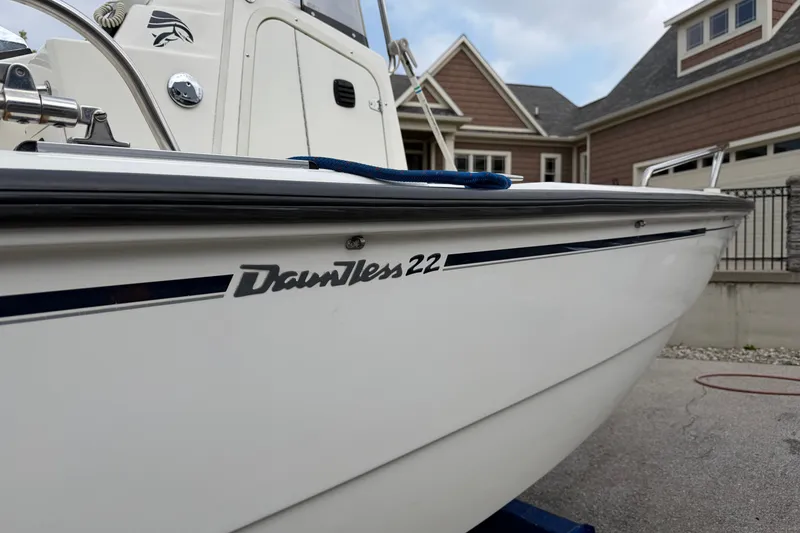 Slide: The Image of 2000 Boston Whaler 22 Dauntless boat, side view, parked near residential homes. - 2