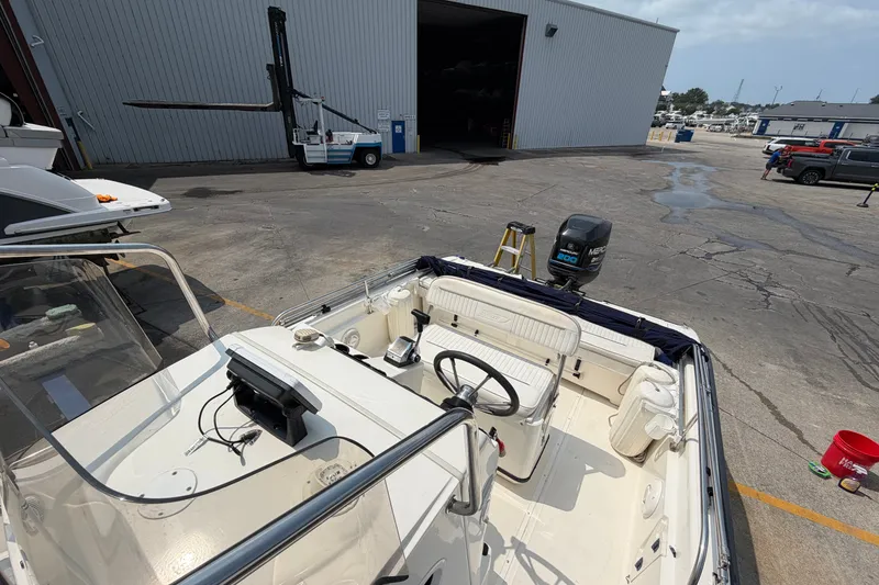 Slide: The Image of 2000 Boston Whaler 22 Dauntless boat with Mercury engine, docked near a warehouse. - 7