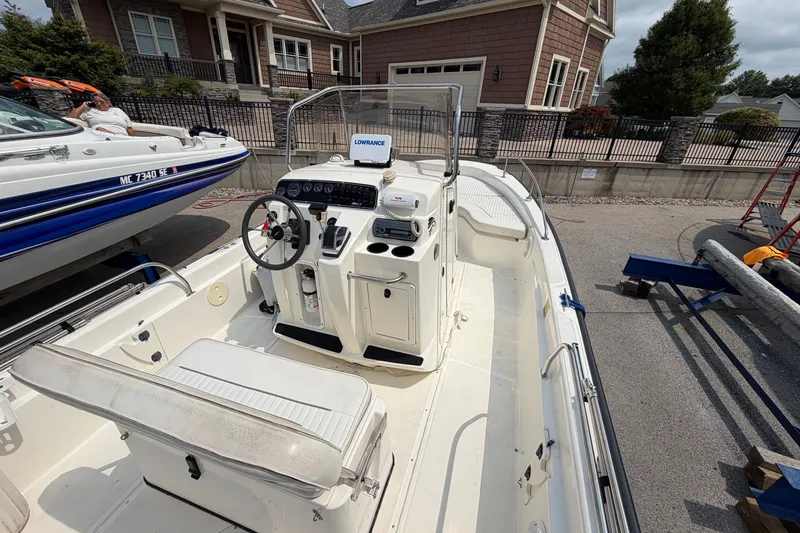 Slide: The Image of 2000 Boston Whaler 22 Dauntless boat with center console, parked near a house. - 4