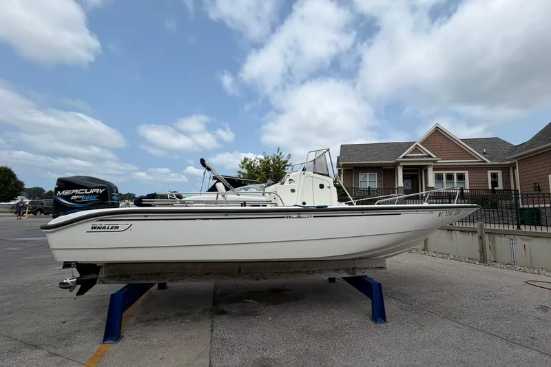 Slide: The Image of 2000 Boston Whaler 22 Dauntless boat on stand, with Mercury outboard motor. - 1