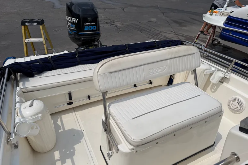 Slide: The Image of 2000 Boston Whaler 22 Dauntless boat interior with Mercury 200 engine, featuring white seating. - 6