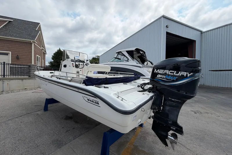 Slide: The Image of 2000 Boston Whaler 22 Dauntless boat with Mercury OptiMax engine, docked outdoors. - 19