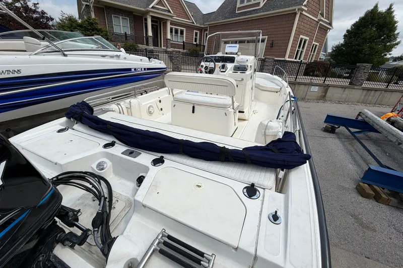 Slide: The Image of 2000 Boston Whaler 22 Dauntless boat docked near a house, showcasing its spacious deck. - 3