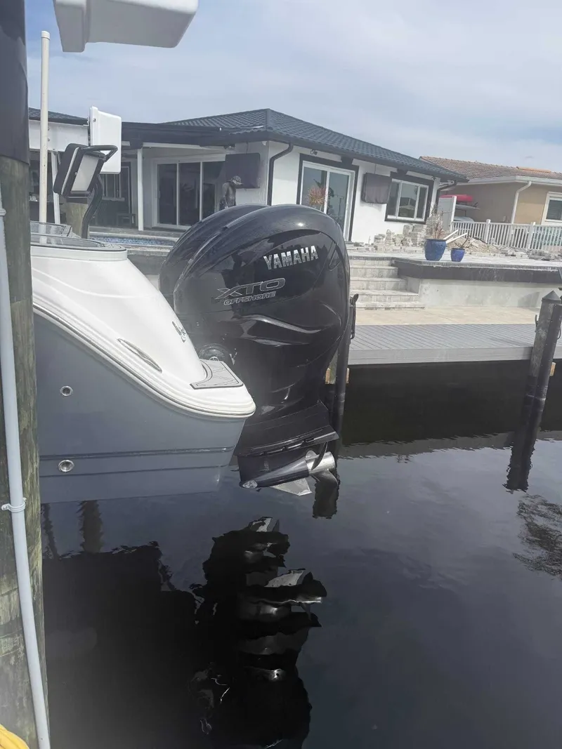 Slide: The Image of A Yamaha outboard motor is attached to a boat docked in a calm harbor. - 8