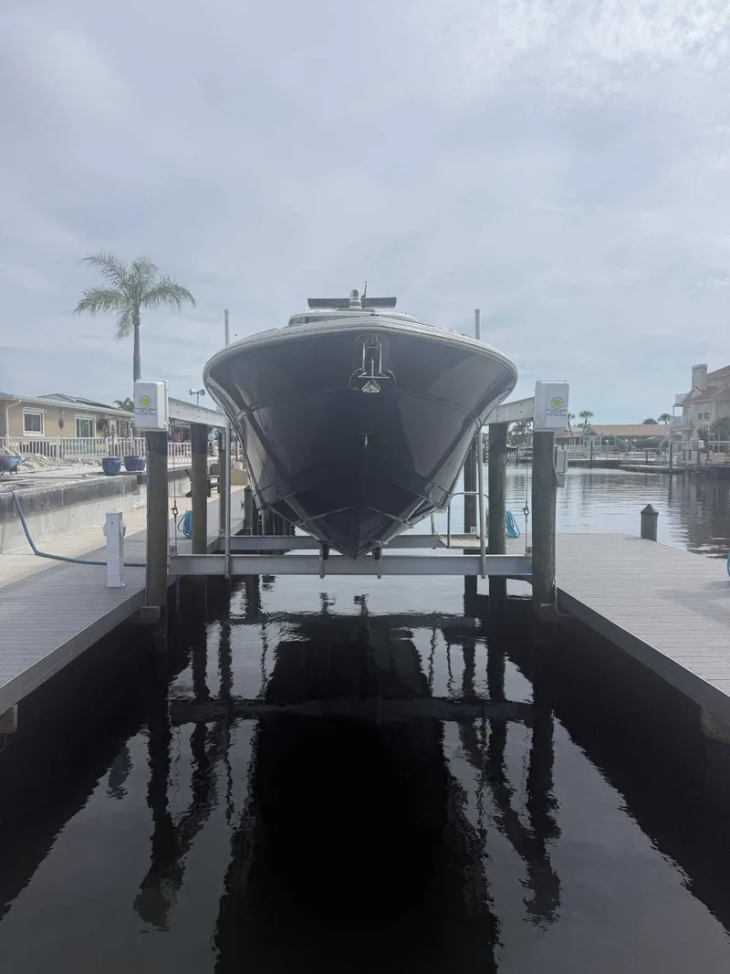 Slide: The Image of A 2025 Sea Fox 328 Commander is on a boat lift above the water. Palm trees in the background. - 6