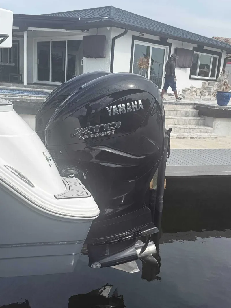Slide: The Image of A Yamaha XTO outboard motor on a Sea Fox 328 Commander boat docked by a house. - 11