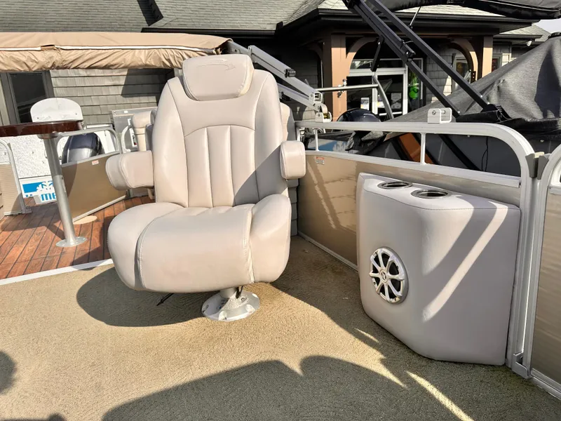 Slide: The Image of 2015 Bennington S24 boat interior with beige captain's chair and speaker. - 15