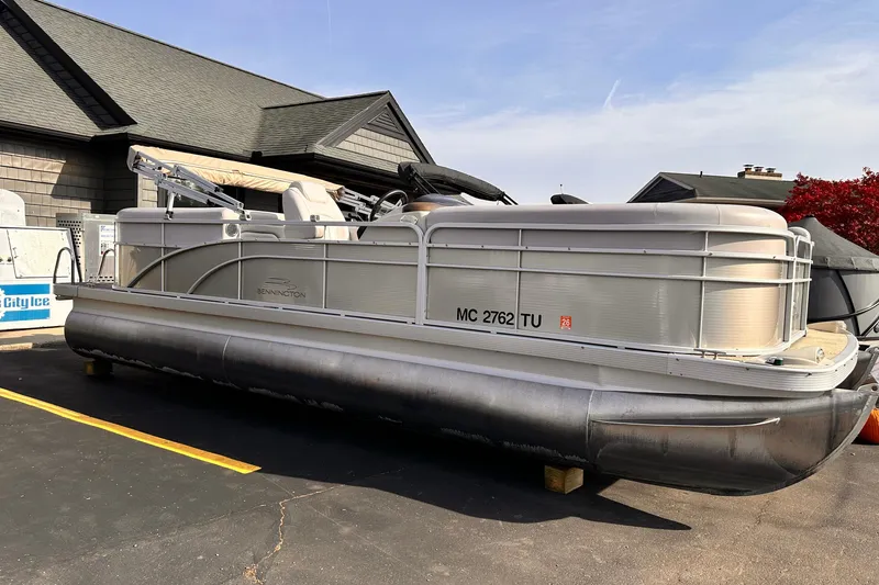 The Image of 2015 Bennington S24 pontoon boat parked on asphalt near a building. - 0