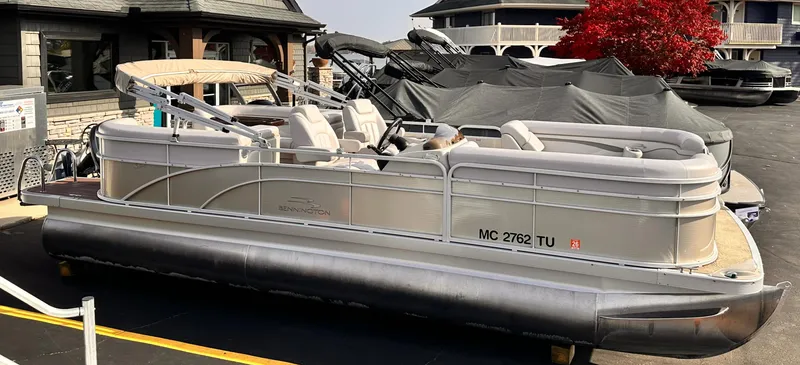 Slide: The Image of 2015 Bennington S24 pontoon boat parked near buildings. - 2