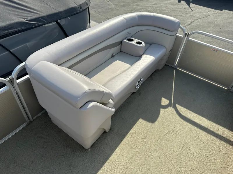 Slide: The Image of 2015 Bennington S24 boat interior with beige seating and cup holders. - 8