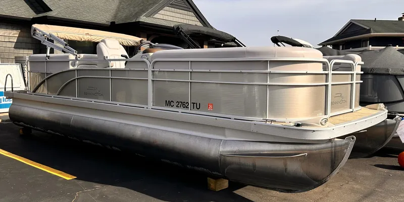Slide: The Image of 2015 Bennington S24 pontoon boat parked on pavement near buildings. - 1