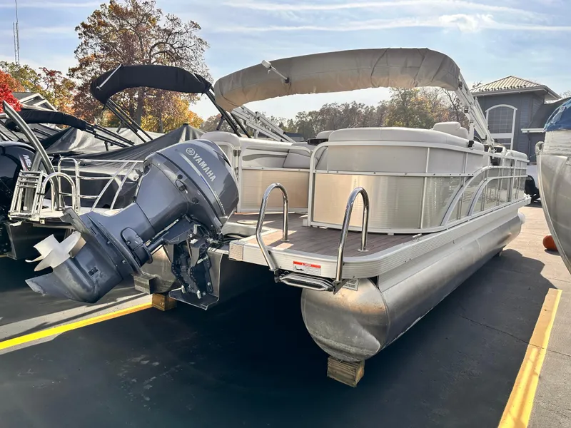 Slide: The Image of 2015 Bennington S24 pontoon boat with Yamaha outboard motor, parked outdoors. - 4