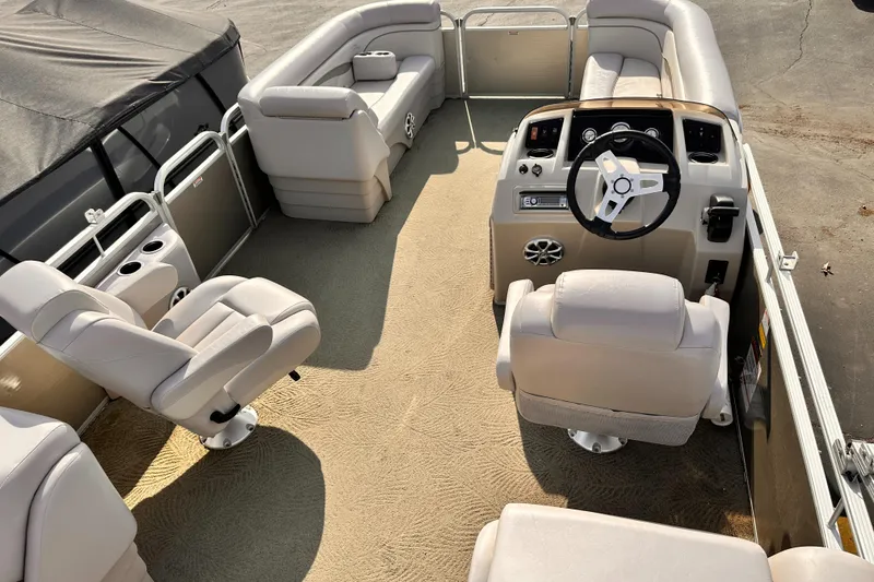 Slide: The Image of 2015 Bennington S24 pontoon boat interior with beige seating and steering console. - 10