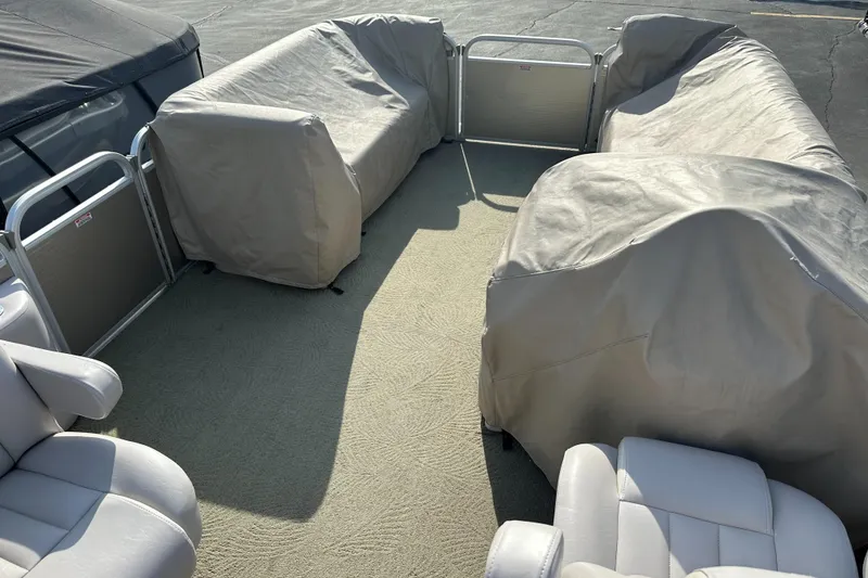 Slide: The Image of 2015 Bennington S24 pontoon boat interior with covered seating and carpeted floor. - 21