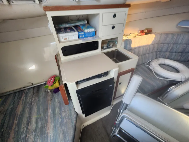 Slide: The Image of Interior of a 1996 Albin 28 Tournament Express with a small kitchenette, sink, and seating area. - 15