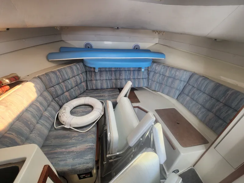 Slide: The Image of Interior of a 1996 Albin 28 Tournament Express with cushioned seating and a life ring. - 17