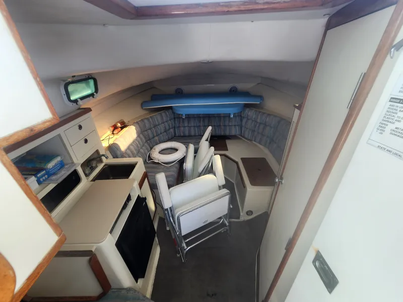 Slide: The Image of Interior of a 1996 Albin 28 Tournament Express with seating and kitchenette. - 12
