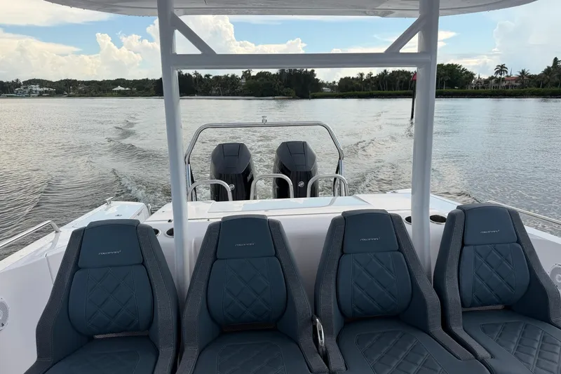 Slide: The Image of 2024 Axopar 37 Sun-Top boat interior with four seats and dual engines on water. - 8