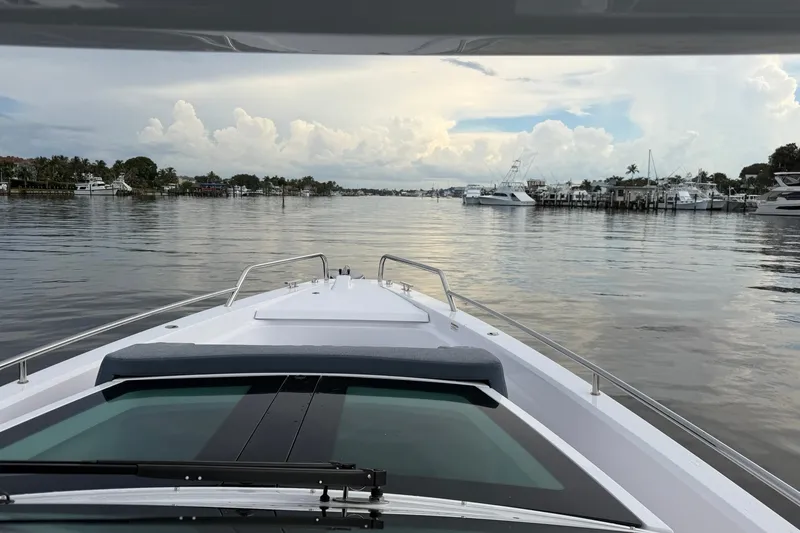 Slide: The Image of 2024 Axopar 37 Sun-Top cruising on a calm, scenic waterway. - 10