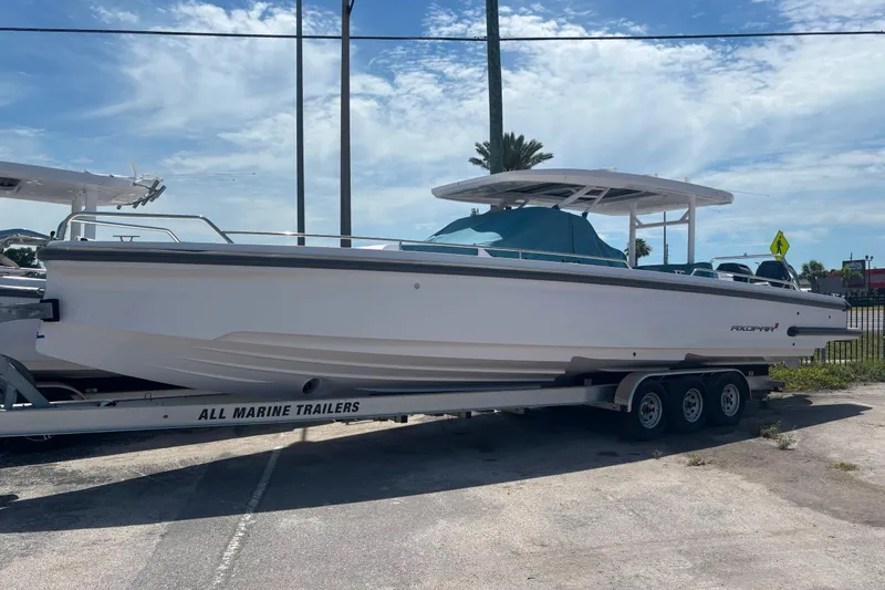 Slide: The Image of 2024 Axopar 37 Sun-Top boat on trailer under clear sky. - 11