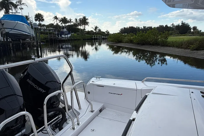Slide: The Image of 2024 Axopar 37 Sun-Top boat with Mercury engines on a serene waterway. - 7