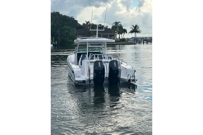 Slide: The Image of 2024 Axopar 37 Sun-Top boat with dual engines on a calm waterway. - 4