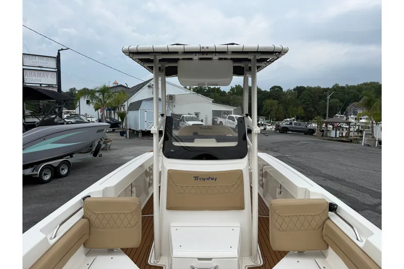Slide: The Image of 2022 Bayliner Trophy T20CX boat interior with seating and console, docked at a marina. - 3