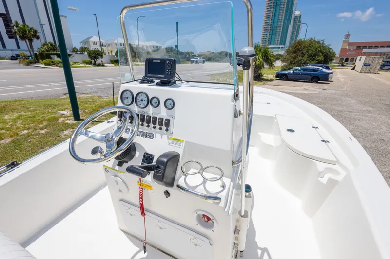 Slide: The Image of 2012 Sea Fox 180 Viper boat console with steering wheel and gauges, parked near a road. - 31