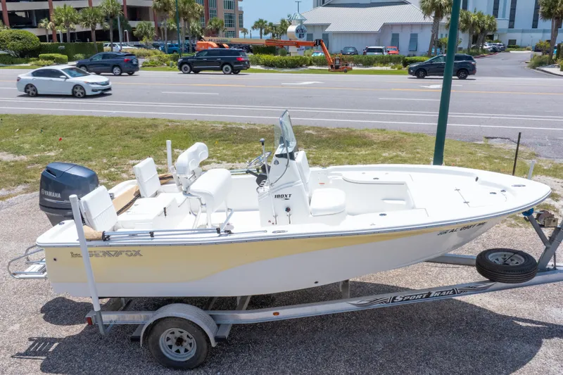 Slide: The Image of 2012 Sea Fox 180 Viper boat on trailer, parked near a road with passing cars. - 2